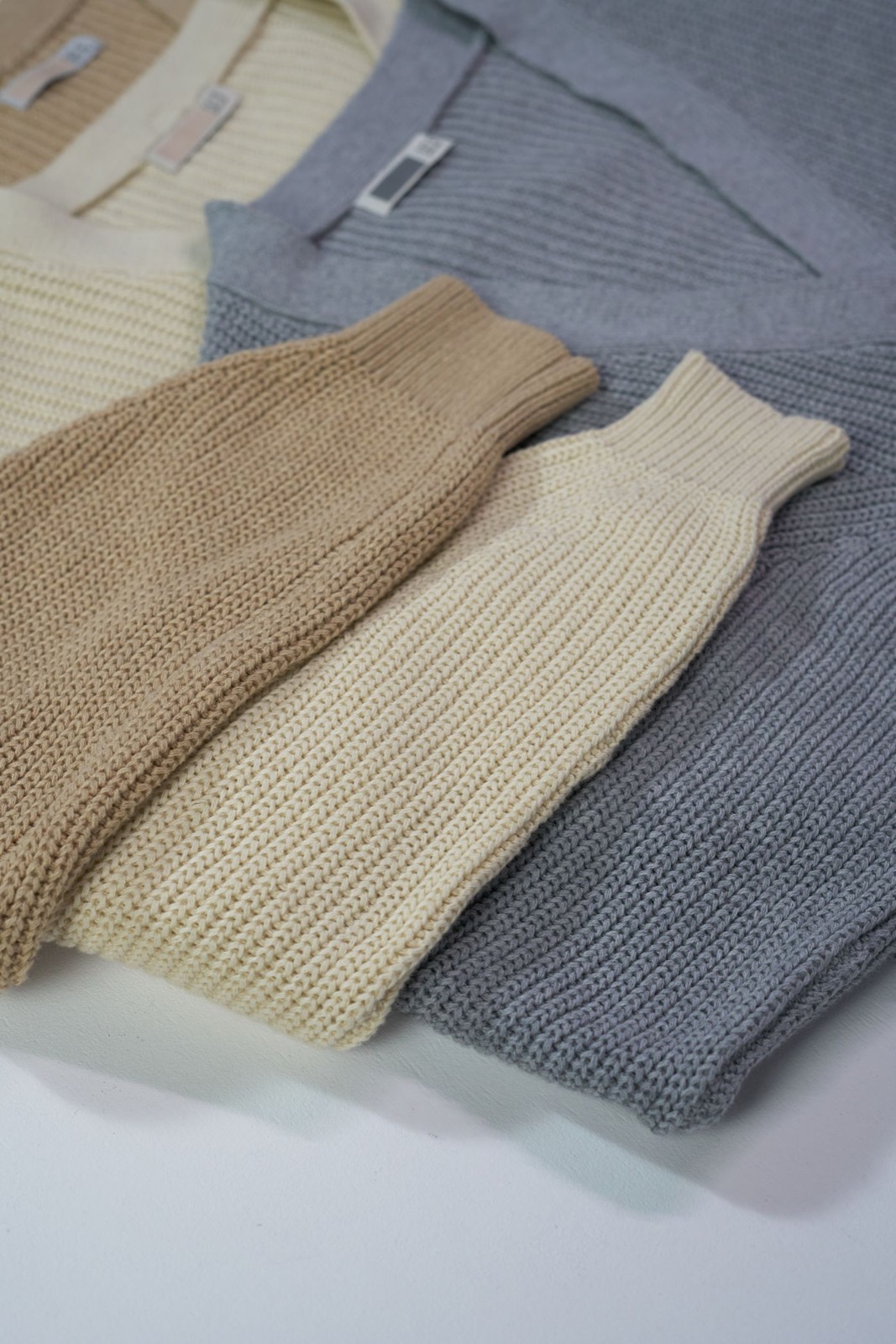 Folded cream, sand and grey knits