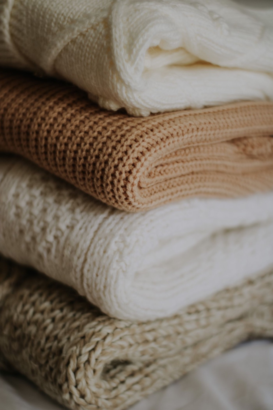 A stack of cream and camel knits