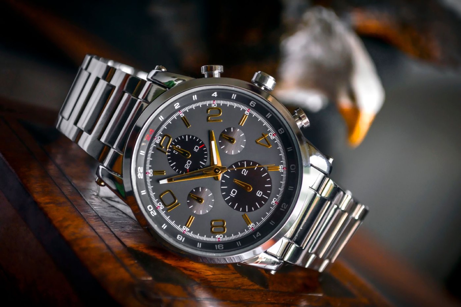 A plain metal watch on dark wood