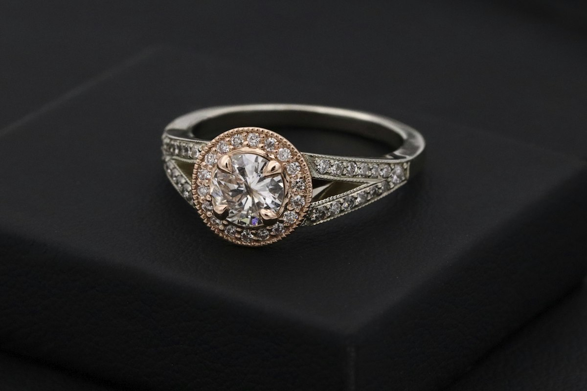 Halo ring with a round center stone on a dark box